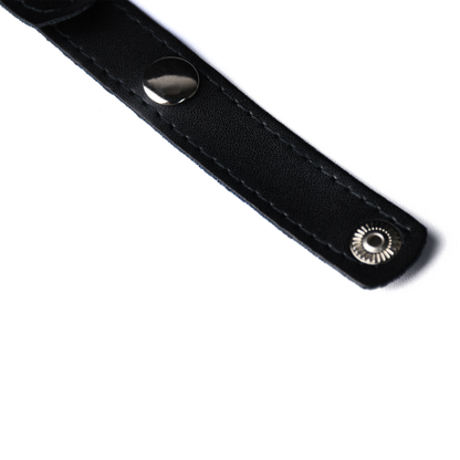 Close-up of a snap-fastening end on the black PU belt